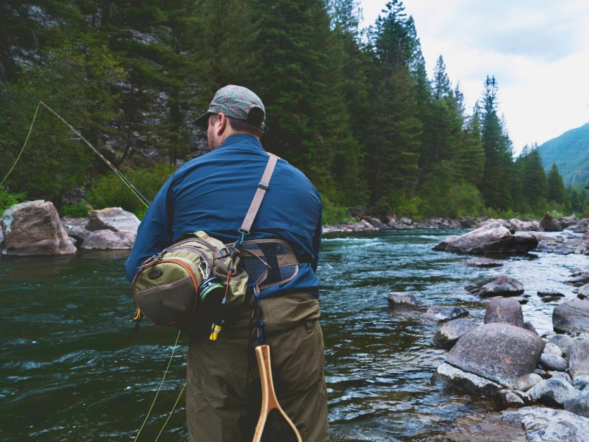 Here's a trout fisher with fishing bag and landing net our pursuing some delicious streamy mountain water.