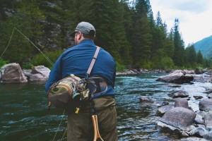 Here's a trout fisher with fishing bag and landing net our pursuing some delicious streamy mountain water.